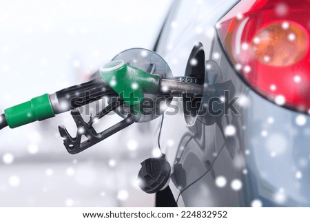 transportation, tanking and vehicle concept - close up of fuel hose nozzle in car tank