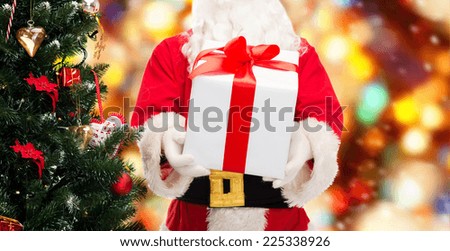 christmas, holidays and people concept - close up of santa claus with gift box and tree over red lights background