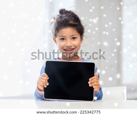 education, winter, technology and people concept - smiling little girl with tablet pc at home