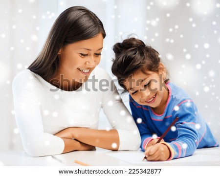 childhood, family, education and people concept - smiling little girl and mother or teacher drawing with coloring pencils indoors