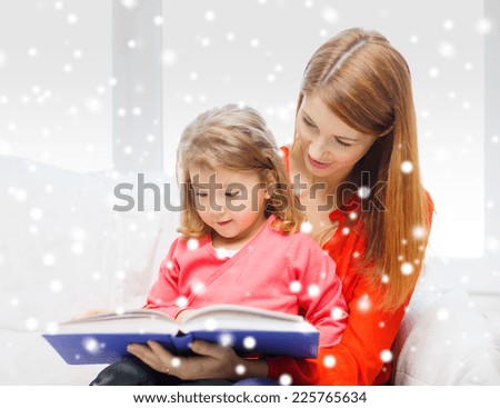 family, childhood, holidays, finances and people concept - happy mother and daughter with book at home