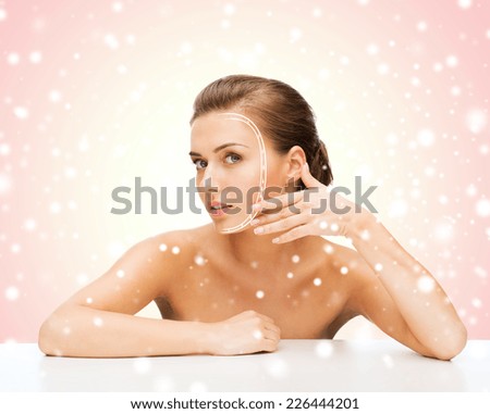 beauty, health, people and medicine concept - beautiful young woman with lines on face over pink snowy background