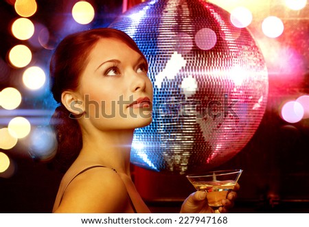 luxury, vip, nightlife, party concept - beautiful woman in evening dress with cocktail and disco ball