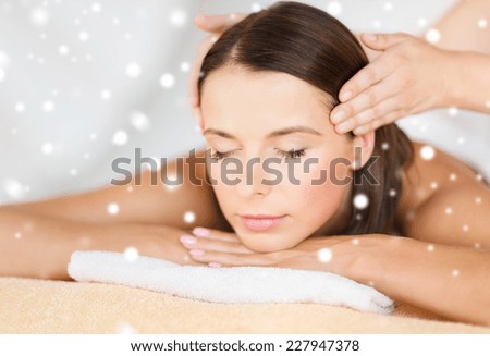 beauty, health, holidays, people and spa concept - beautiful woman in spa salon getting face or head massage