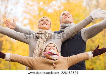 family, childhood, season and people concept - happy family having fun in autumn park