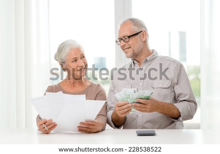 family, savings, age and people concept - smiling senior couple with papers, money and calculator at home