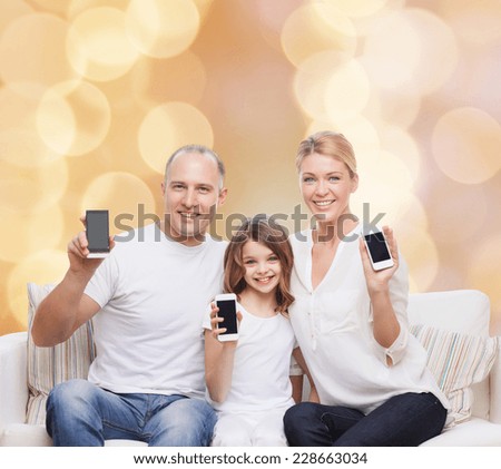 holidays, technology, advertisement and people concept - smiling family with smartphones over beige lights background