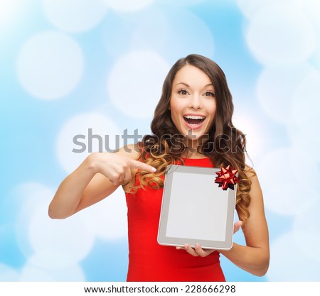 christmas, technology, present and people concept - smiling woman in red dress with blank tablet pc computer screen over blue lights background