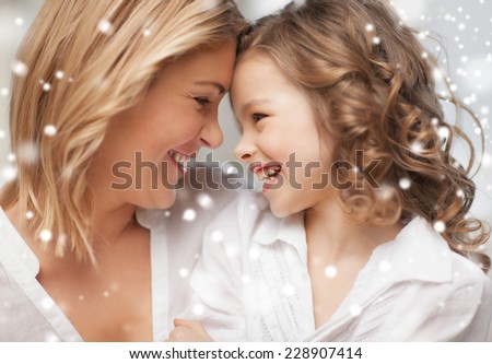 people, motherhood, family, winter and adoption concept - happy mother and daughter cuddling at home