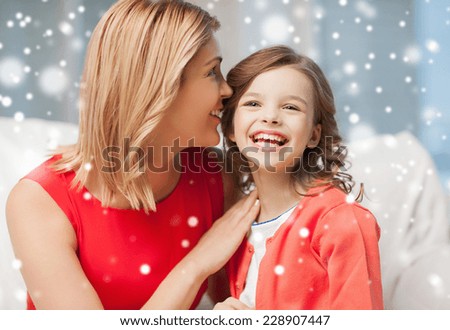 people, motherhood, family, winter and adoption concept - happy mother and daughter whispering something into ear at home