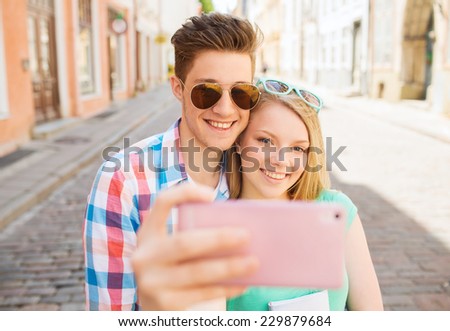travel, vacation, technology and friendship concept - smiling couple with smartphone in city