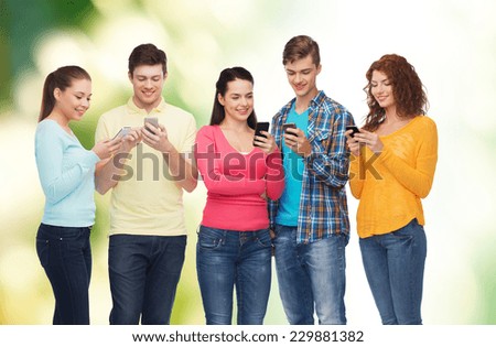 friendship, technology, ecology and people concept - group of smiling teenagers with smartphones over natural background