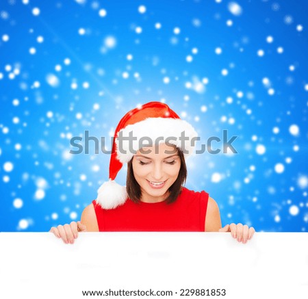 christmas, x-mas, people, advertisement and sale concept - happy woman in santa helper hat with blank white board over blue snowy background
