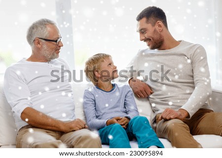 family, happiness, generation and people concept - smiling father, son and grandfather sitting on couch at home