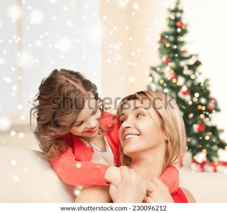 people, motherhood, family, christmas and adoption concept - happy mother and daughter hugging at home