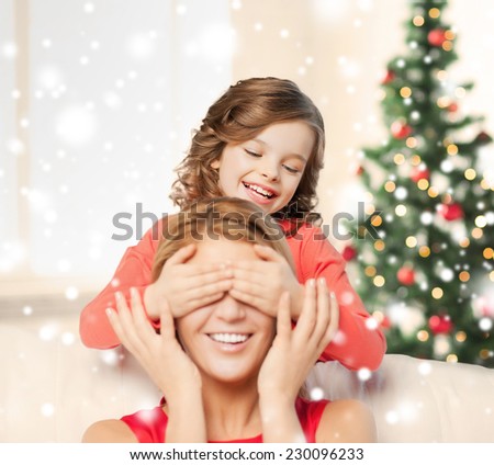 people, motherhood, family, christmas and adoption concept - happy mother and daughter playing and having fun at home