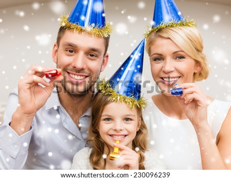 celebration, family, holidays and birthday concept - happy family wearing blue party hats and blowing favor horns at home