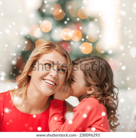 people, motherhood, family, christmas and adoption concept - happy mother and daughter whispering something into ear at home