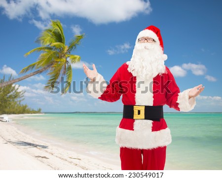christmas, holidays, travel and people concept - man in costume of santa claus over tropical beach background