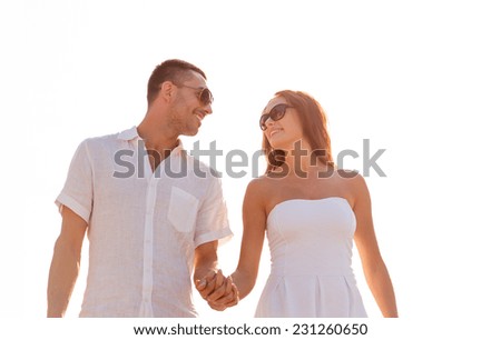 love, travel, tourism, sailing, people and friendship concept - smiling couple wearing sunglasses walking outdoors