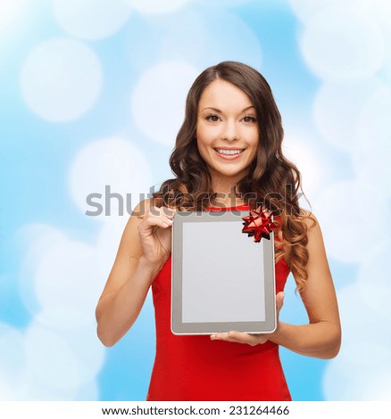 christmas, holidays, technology and people concept - smiling woman in red dress with tablet pc computer over blue lights background