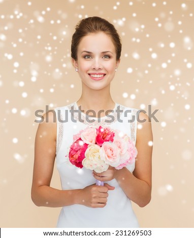 happiness, wedding, holidays and celebration concept - smiling bride or bridesmaid in white dress with bouquet of flowers over beige background and snow