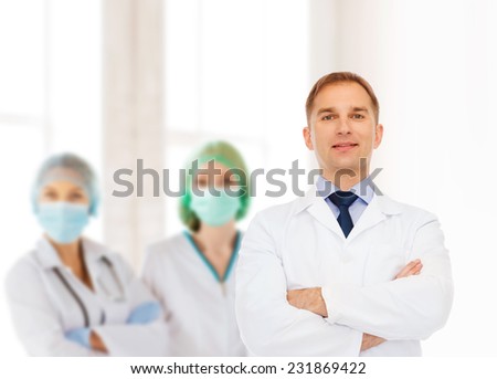 healthcare, profession, teamwork and medicine concept - smiling male doctor in white coat over group of medics