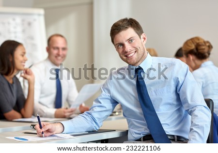 business, people and teamwork concept - smiling businessman with group of businesspeople meeting in office