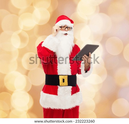 christmas, holidays, technology and people concept - man in costume of santa claus with tablet pc computer over beige lights background