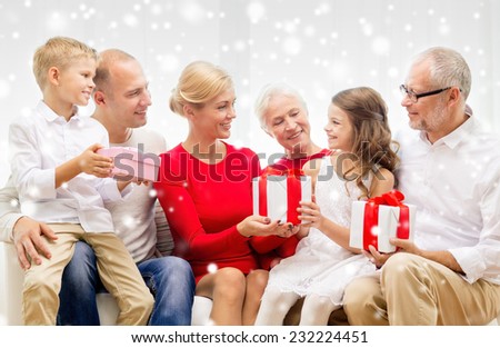 family, holidays, generation, christmas and people concept - smiling family giving each other presents  at home