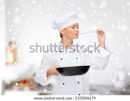 cooking, holidays, people and food concept - smiling female chef with pan and spoon tasting food over kitchen background