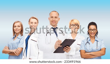 medicine, profession, teamwork and healthcare concept - international group of smiling medics or doctors with clipboard and stethoscopes over blue background