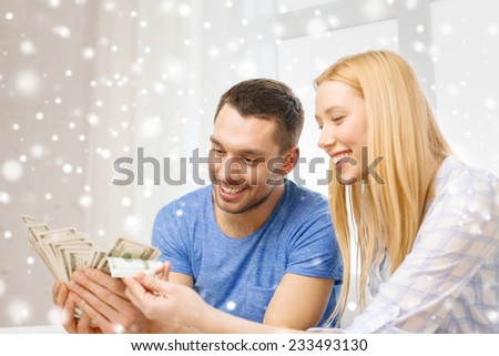love, family, finance, money and happiness concept - happy couple with cash money at home