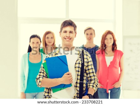 education and school concept - group of smiling students with teenage boy in front with bag and folders