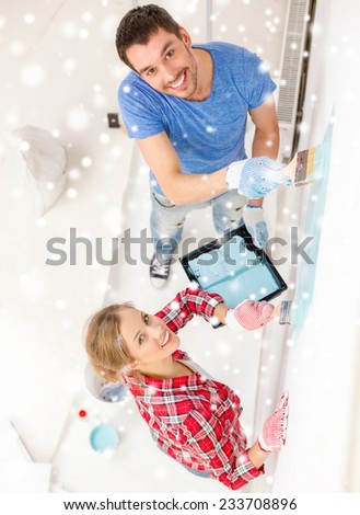 repair, building, love, people and home concept - smiling couple with paintbrushes painting wall at home