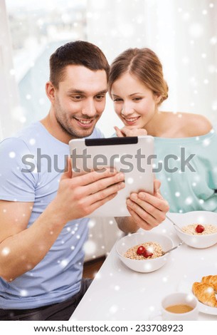 food, family, people and technology concept - smiling couple with tablet pc computer reading news and having breakfast at home