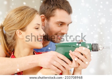 repair, interior design, building, renovation and family concept - smiling couple drilling hole in wall at home