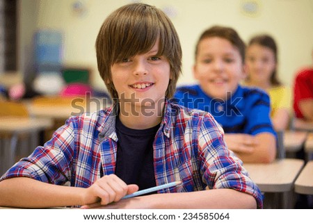 education, elementary school, learning and people concept - group of smiling school kids sitting in classroom