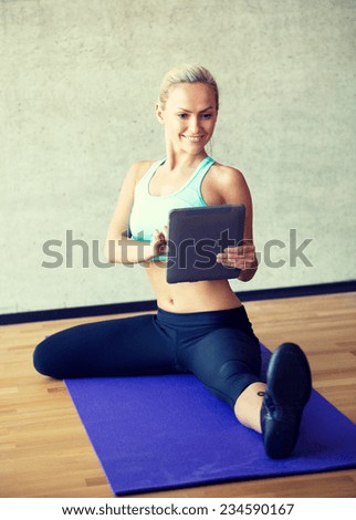 fitness, technology and sport concept - smiling woman with tablet pc sitting on in gym