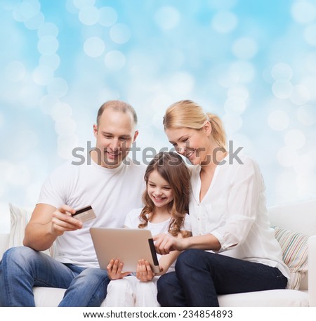 family, christmas holidays, shopping, technology and people - smiling family  with tablet pc computer and credit card over blue lights background