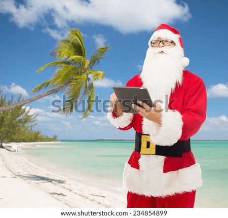 christmas, holidays, travel, technology and people concept - man in costume of santa claus with tablet pc computer over tropical beach background