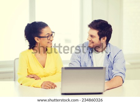 education, technology, business, startup and office concept - two smiling people with laptop in office