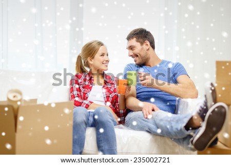 repair, moving, resting in and people concept - smiling couple holding cups drinking tea or coffee at new home