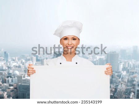 cooking, advertisement and people concept - smiling female chef, cook or baker with white blank board over city background