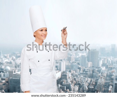 people, cooking and advertisement concept - smiling female chef, cook or baker with marker writing something on air over city background