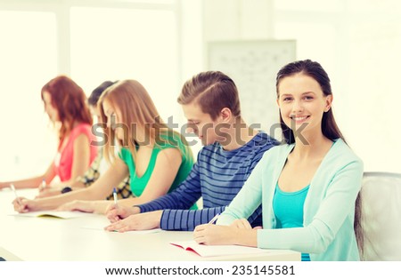 education and school concept - five smiling students with textbooks at school