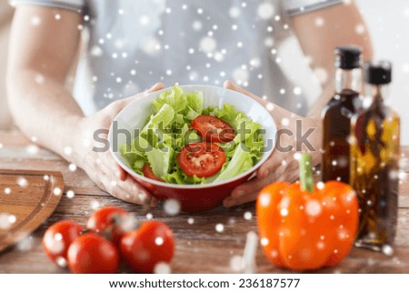 cooking, people, food, vegetarian and home concept - close of male hands holding bowl with salad