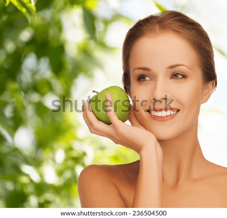 health, beauty, vegetarian food and people concept - smiling young woman with apple over green background