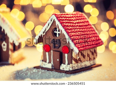 holidays, christmas, baking and sweets concept - closeup of beautiful gingerbread houses on table over lights background