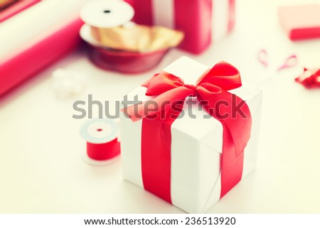 holidays and celebration concept - close up of christmas presents, decoration paper, ribbons and scissors